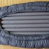 Grey sleeping bag laid flat on a white background (illustrative photo)