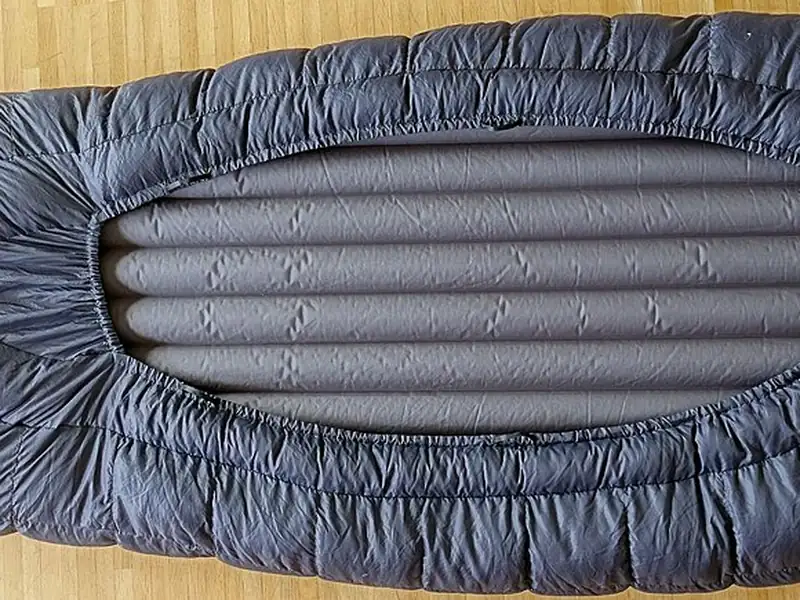 Grey sleeping bag laid flat on a white background (illustrative photo)