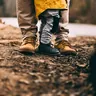 Adult and child in hiking boots on a trail (illustrative photo)