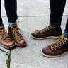 Two people in laced leather boots on a sidewalk (illustrative photo)