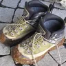 Muddy hiking boots on paving stones (illustrative photo)
