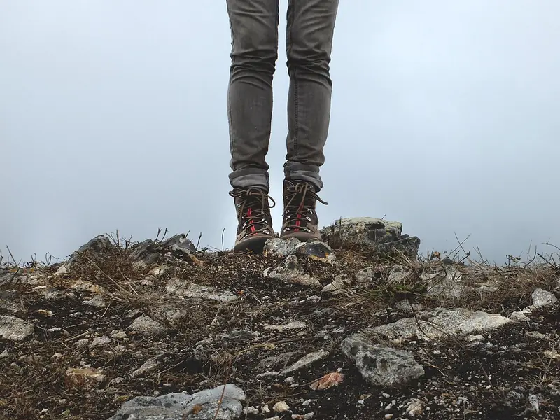 Hiker's boots on a rocky summit (illustrative photo)
