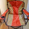 Red folding camp chair with armrests (illustrative photo)