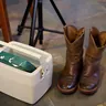 Small white cooler next to a pair of boots (illustrative photo)