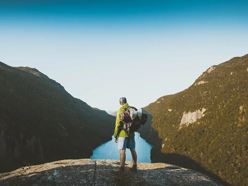 Hiker with a backpack on a rocky ridge (illustrative photo)