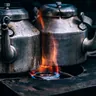 Two steel kettles heating over a flame (illustrative photo)