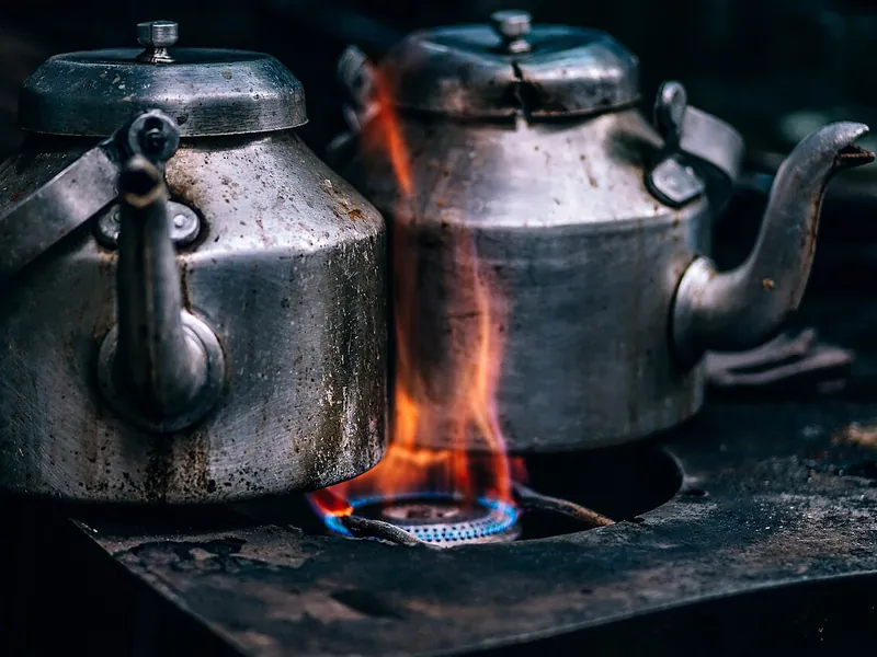 Two steel kettles heating over a flame (illustrative photo)