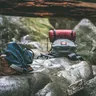 Hiking packs and a rolled sleeping bag on boulders (illustrative photo)