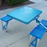 Blue folding camp table with attached seats (illustrative photo)