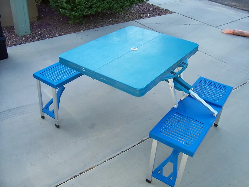 Blue folding camp table with attached seats (illustrative photo)