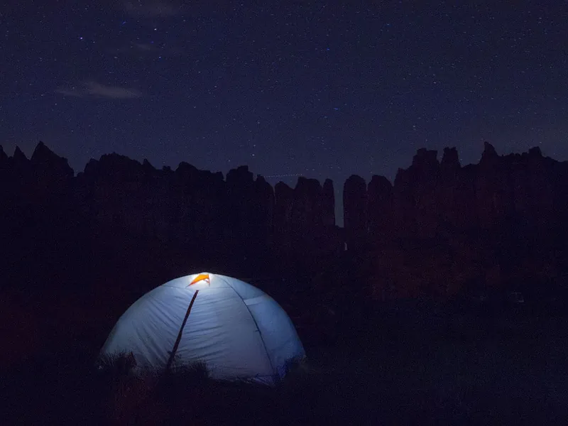 Dome tent glowing from inside at night (illustrative photo)