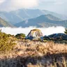 Tent above a valley filled with morning clouds (illustrative photo)