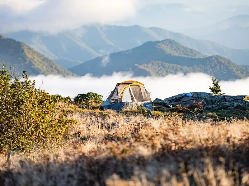 Tent above a valley filled with morning clouds (illustrative photo)