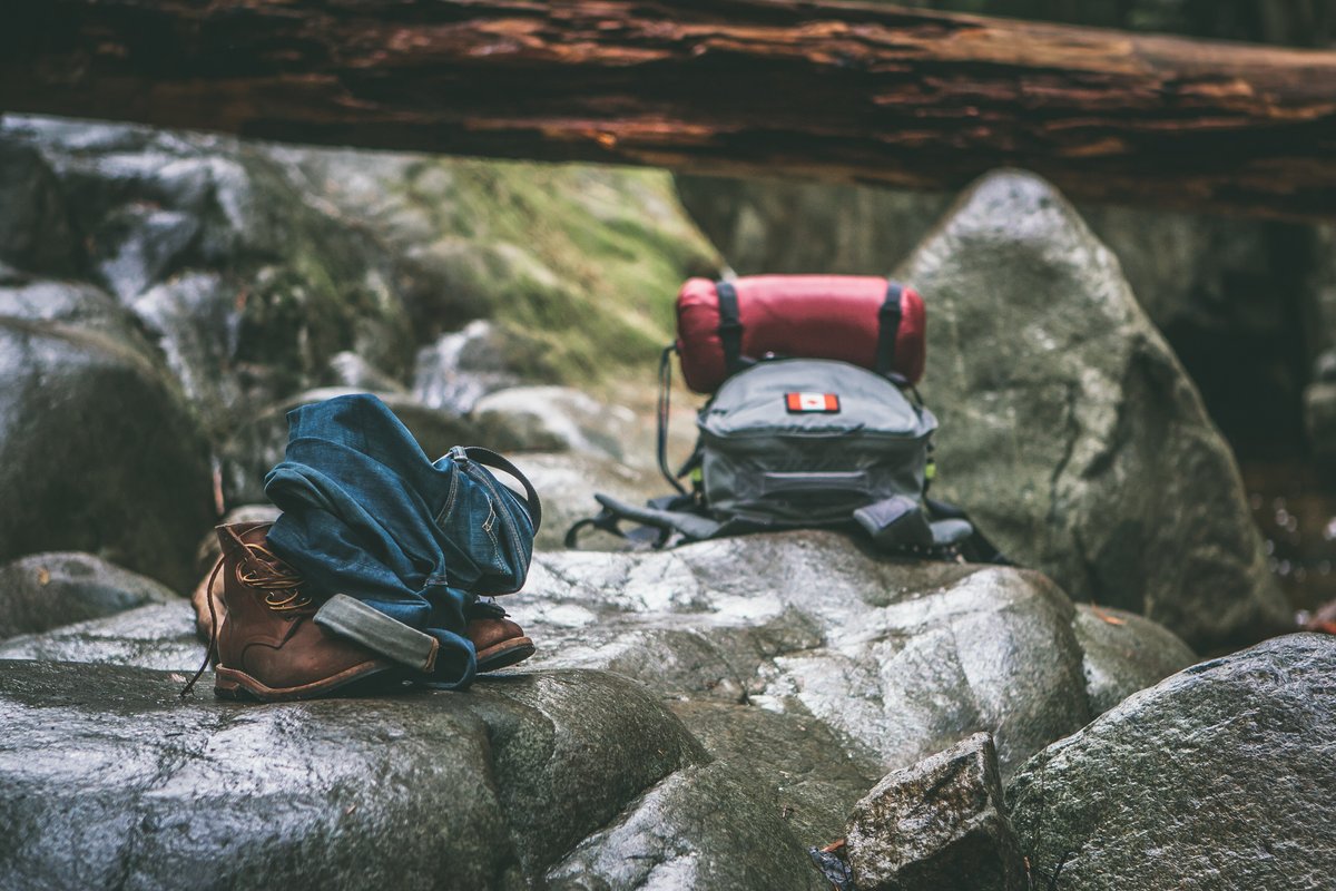 Backpacking gear including a sleeping bag and pack resting on boulders