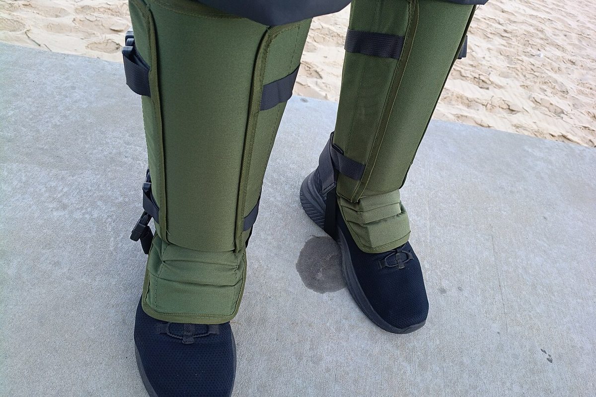 Pair of green protective gaiters worn over hiking shoes
