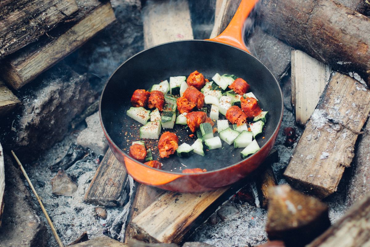 Illustrative photo of a camper cooking at a campsite
