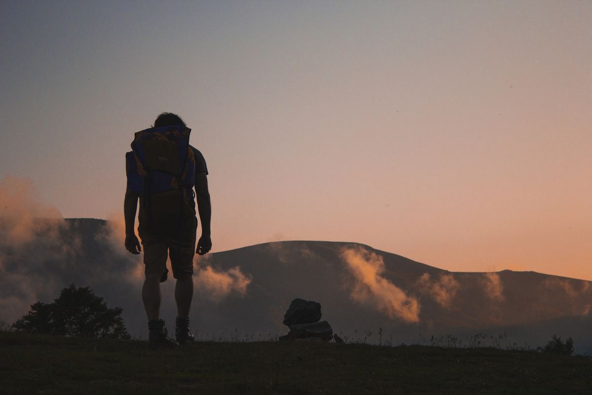 Illustrative photo of hikers on a ridge in bright sunrise light